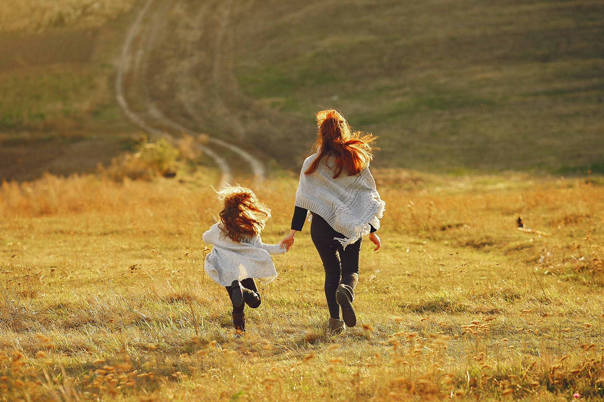Mother with little daughter playing in a autumn field
